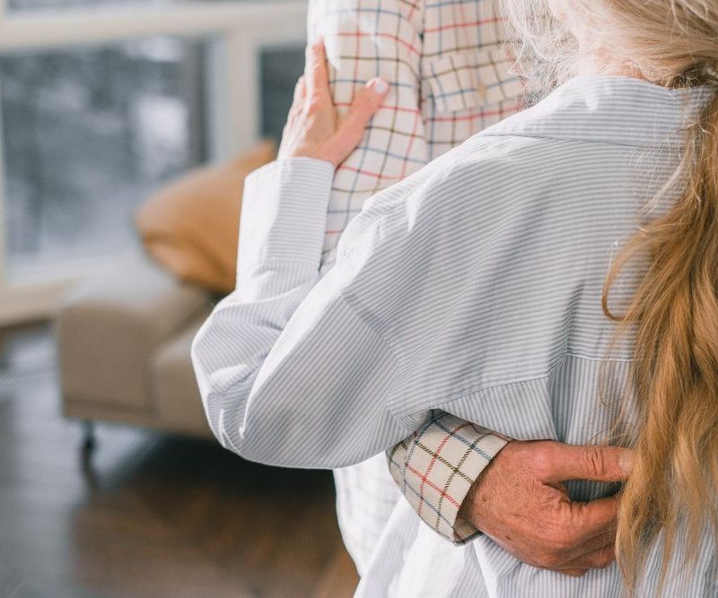 Pflegekraft unterstützt eine Patientin liebevoll und behutsam