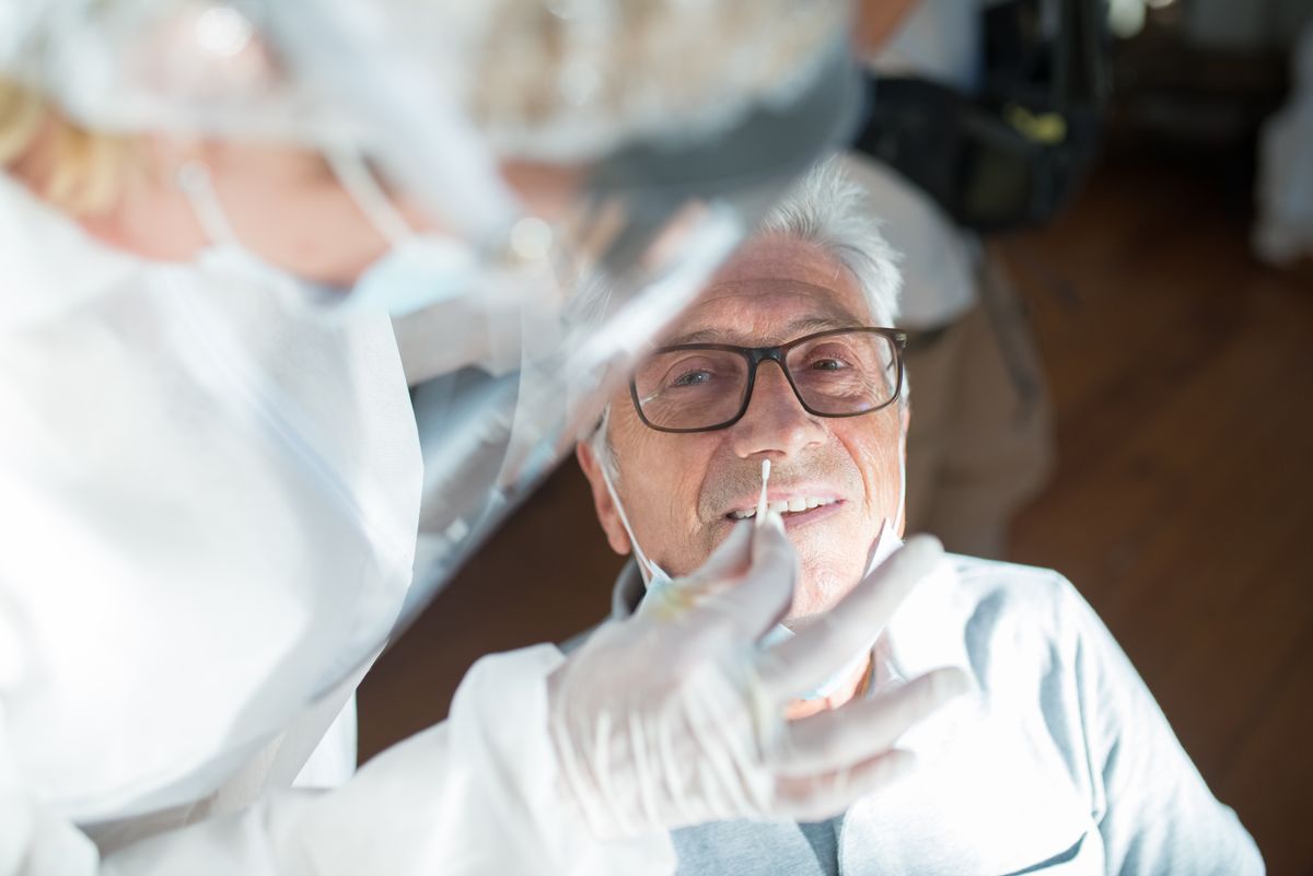 Pflegekraft kümmert sich aufmerksam um einen Patienten zuhause